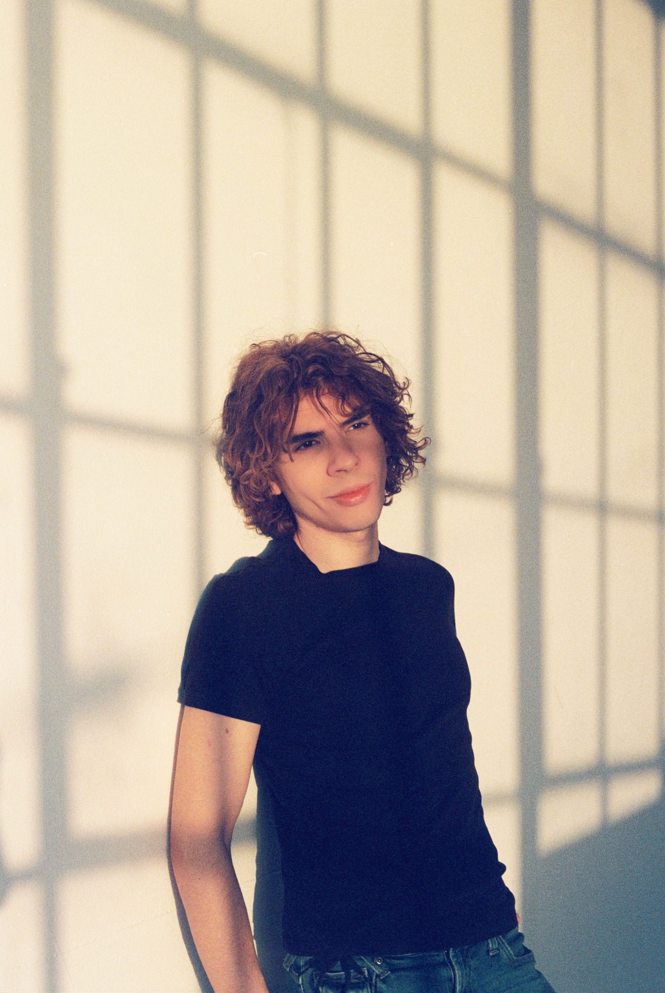 Caner Oz in a black T-shirt with window shadows
