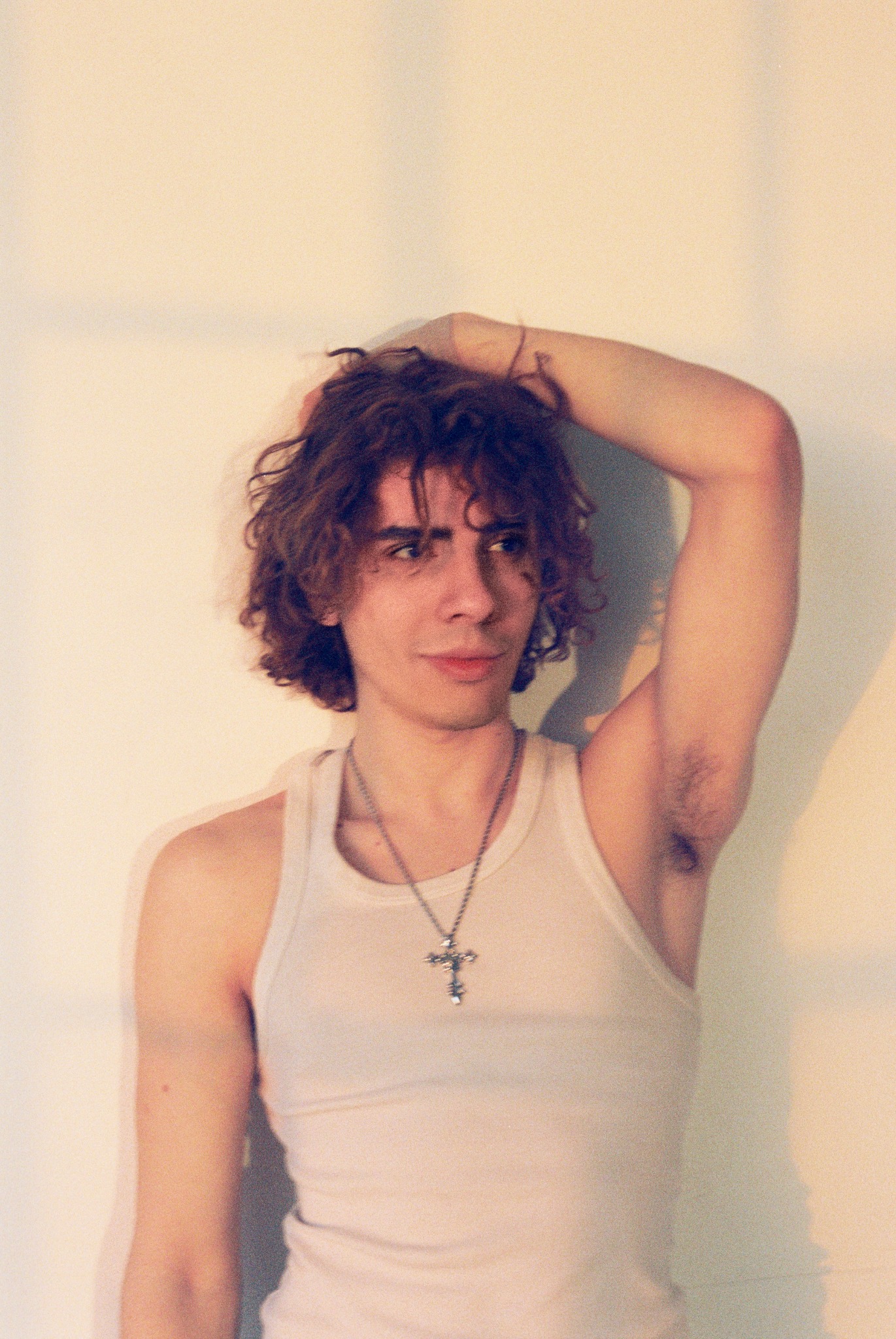 Caner Oz in a white tank top with one arm raised
