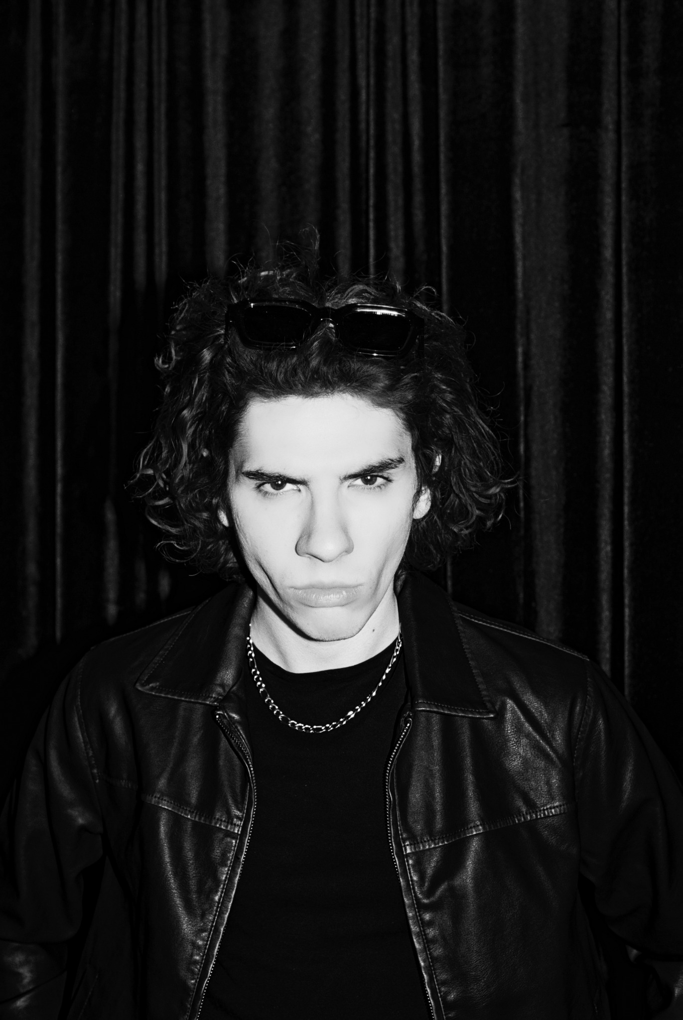 Black-and-white portrait of Caner Oz in a leather jacket