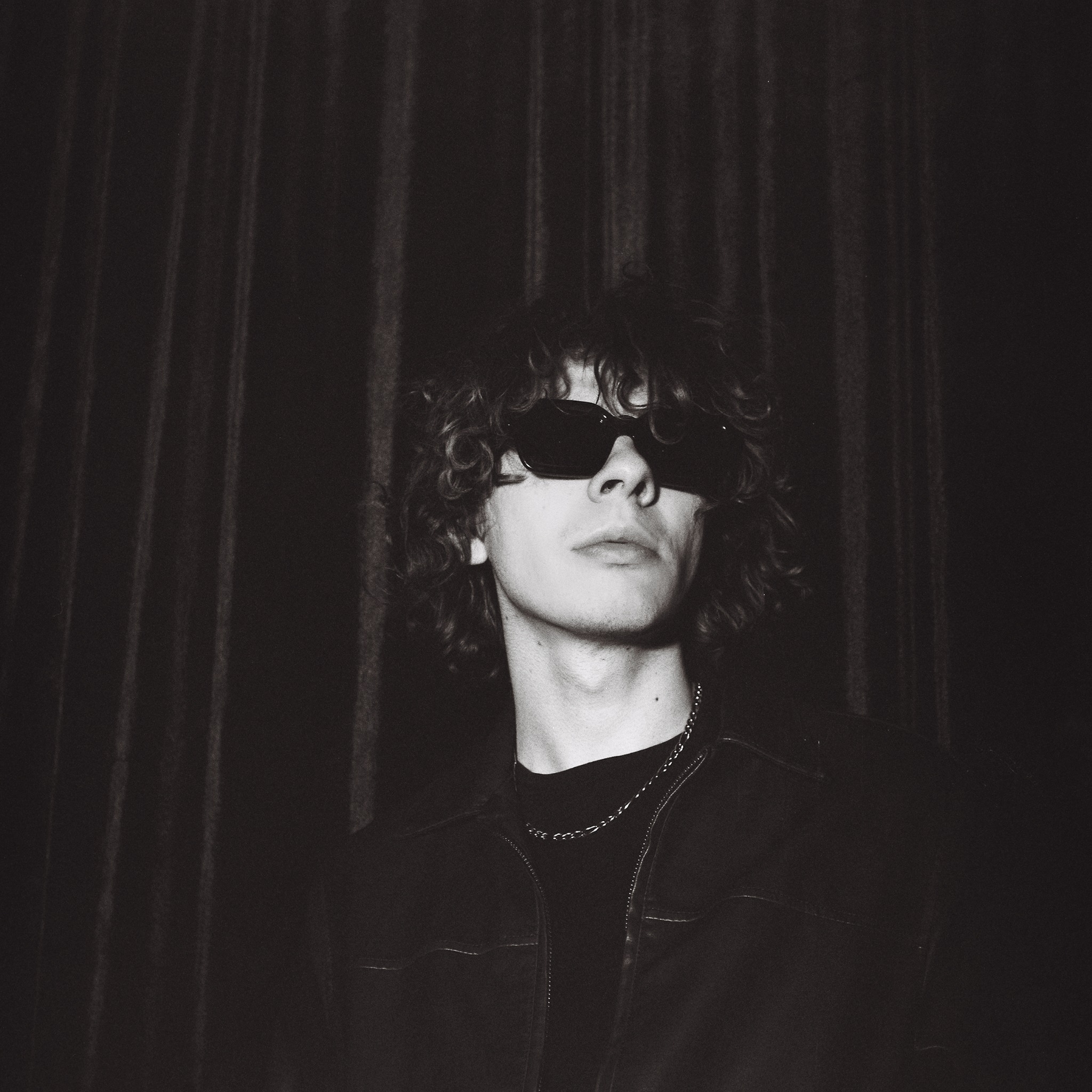 Black-and-white close portrait of Caner Oz in sunglasses