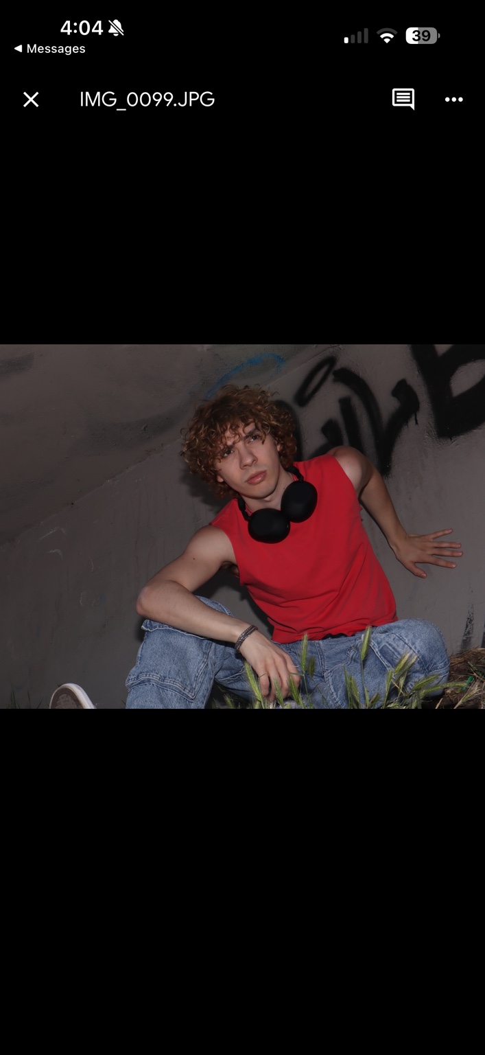 Caner Oz in a red sleeveless shirt with headphones