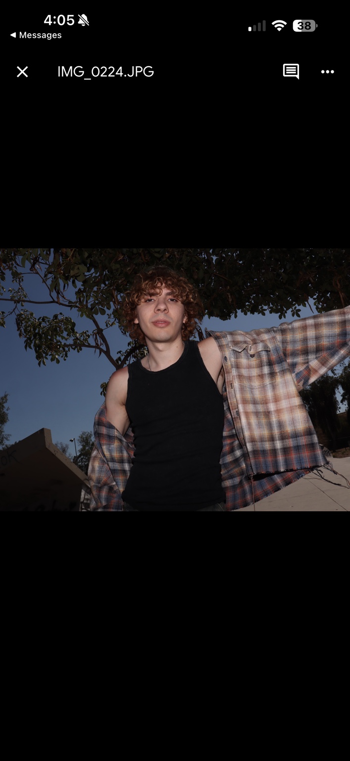 Caner Oz with a plaid overshirt beneath a tree
