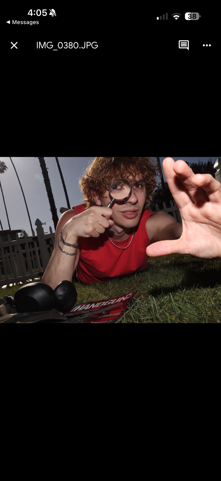 Caner Oz looking through a magnifying glass on the grass